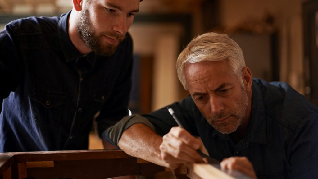 2 Personen die mit Holz arbeiten